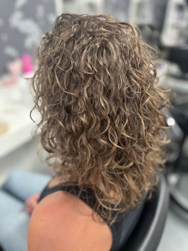 Eine Lockenfrisur, die bis zu den Schultern geht